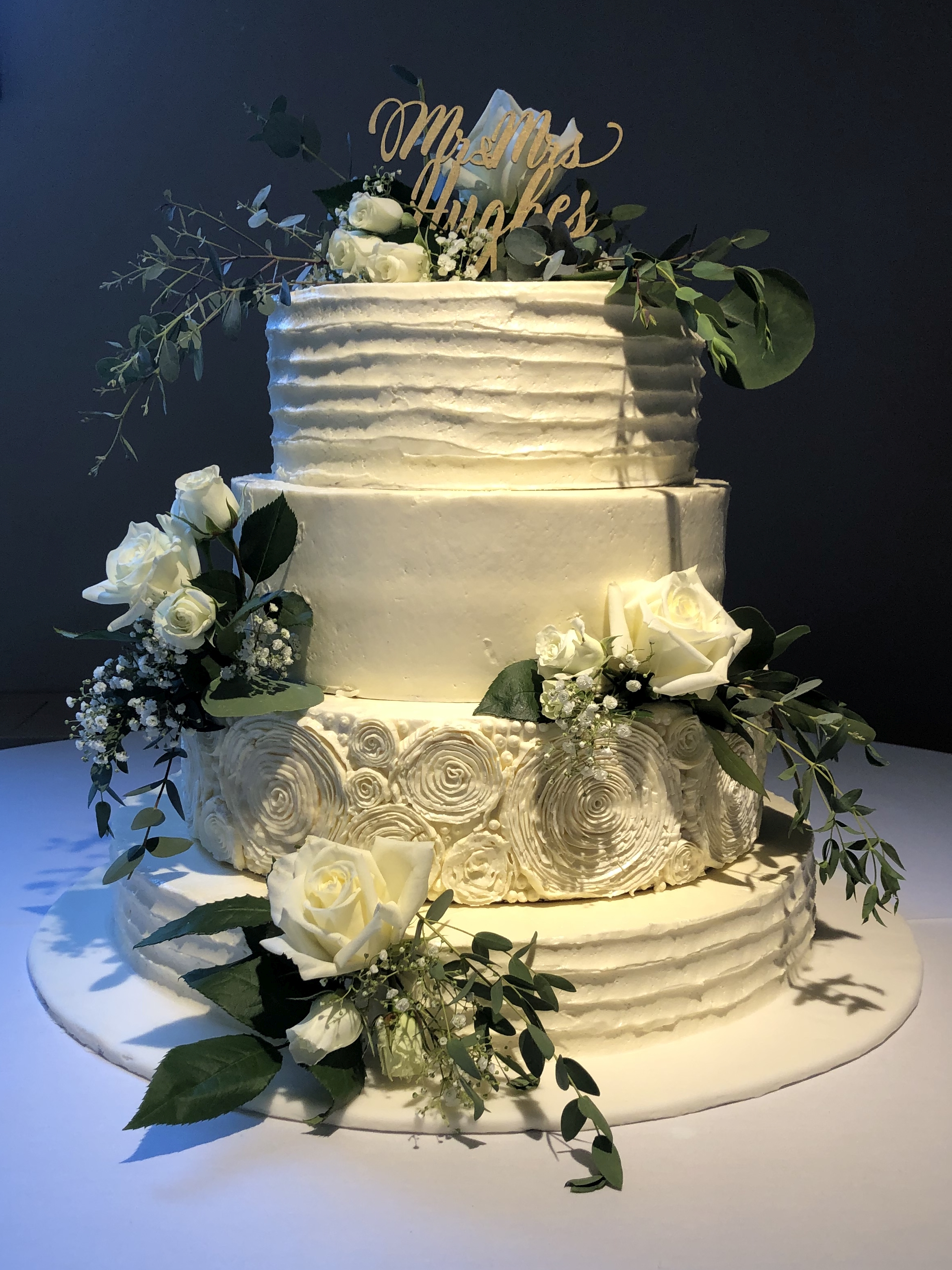 A beautiful 4-tier custom wedding cake with horizontal texture and live flowers from Village Patisserie in Toledo, Ohio