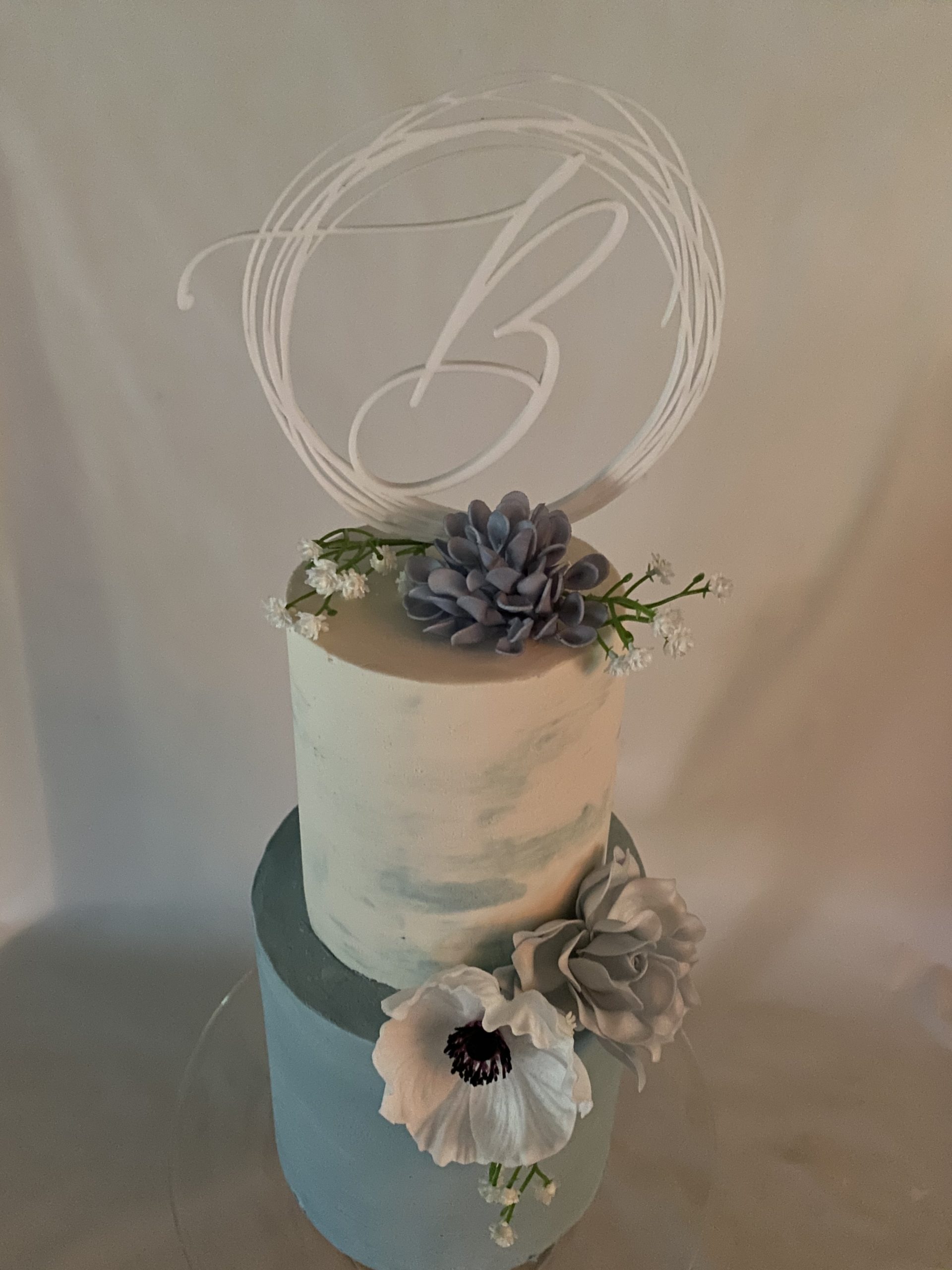 A beautiful 2-tier double barrel custom wedding cake with watercolor finish and live flowers from Village Patisserie in Toledo, Ohio