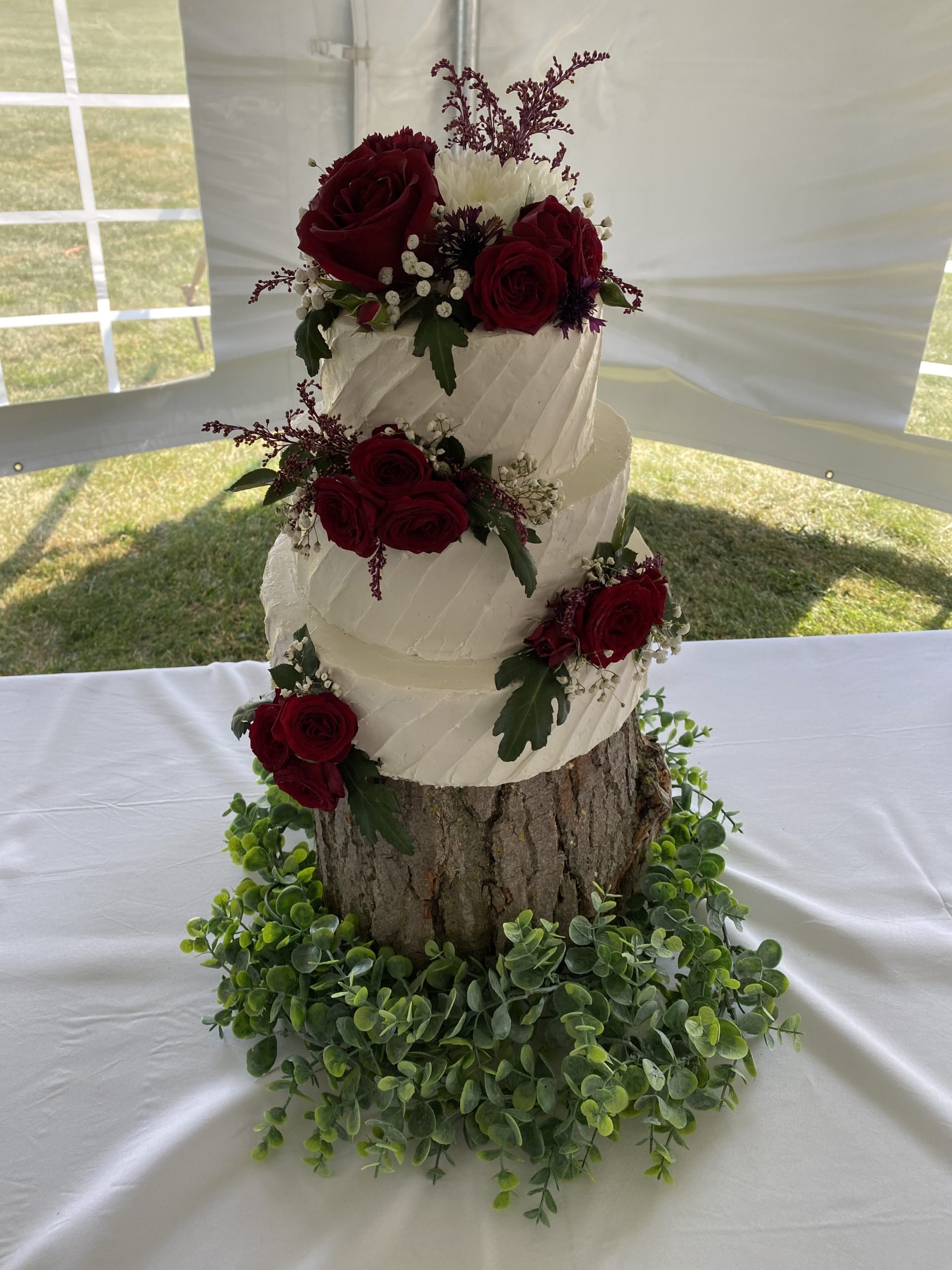 A beautiful 3-tier custom wedding cake with diagonal texture and live flowers from Village Patisserie in Toledo, Ohio
