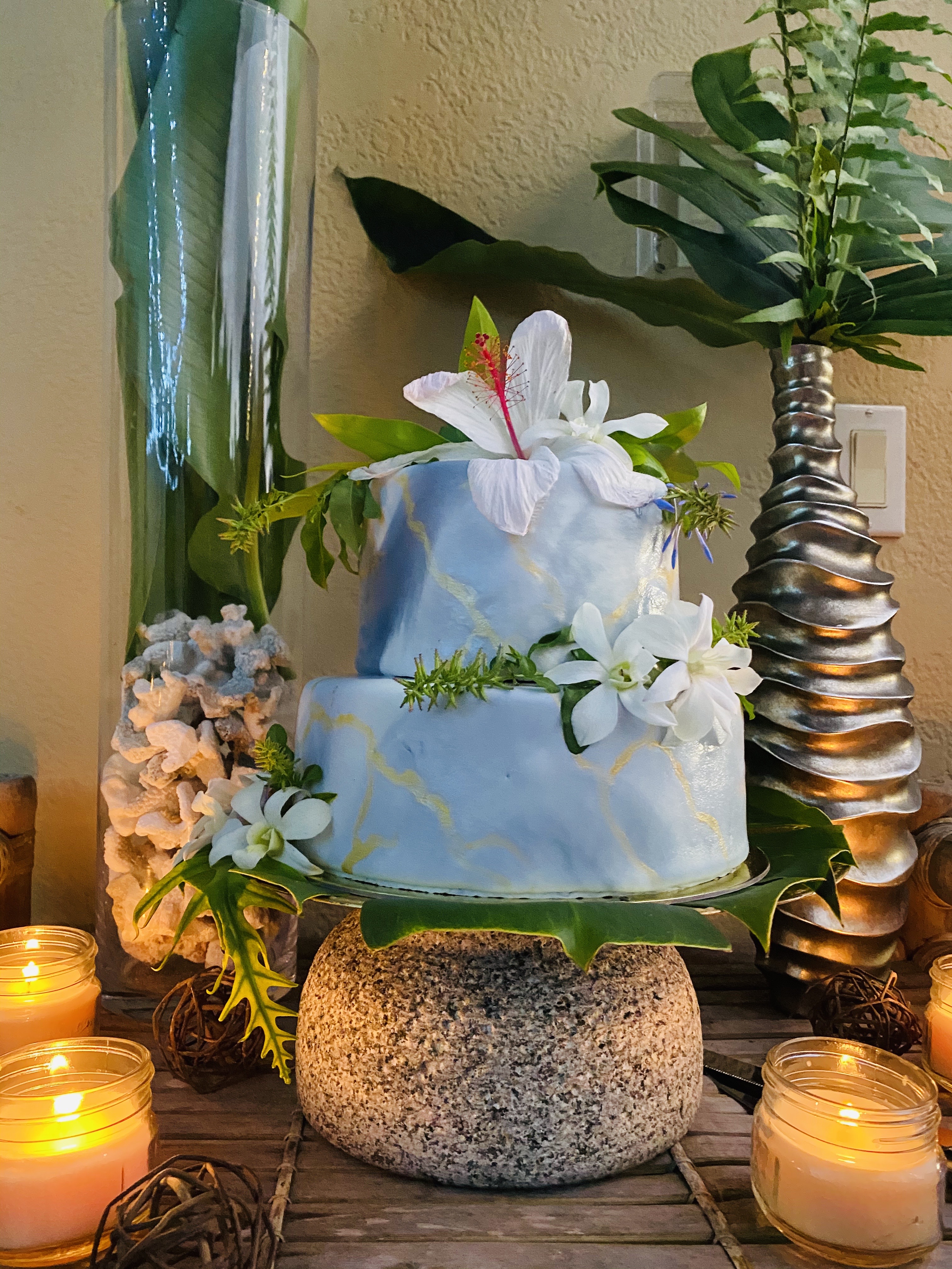 A beautiful 2-tier custom vegan wedding cake with gold leaf and fresh greenery for a destination wedding from Village Patisserie in Toledo, Ohio
