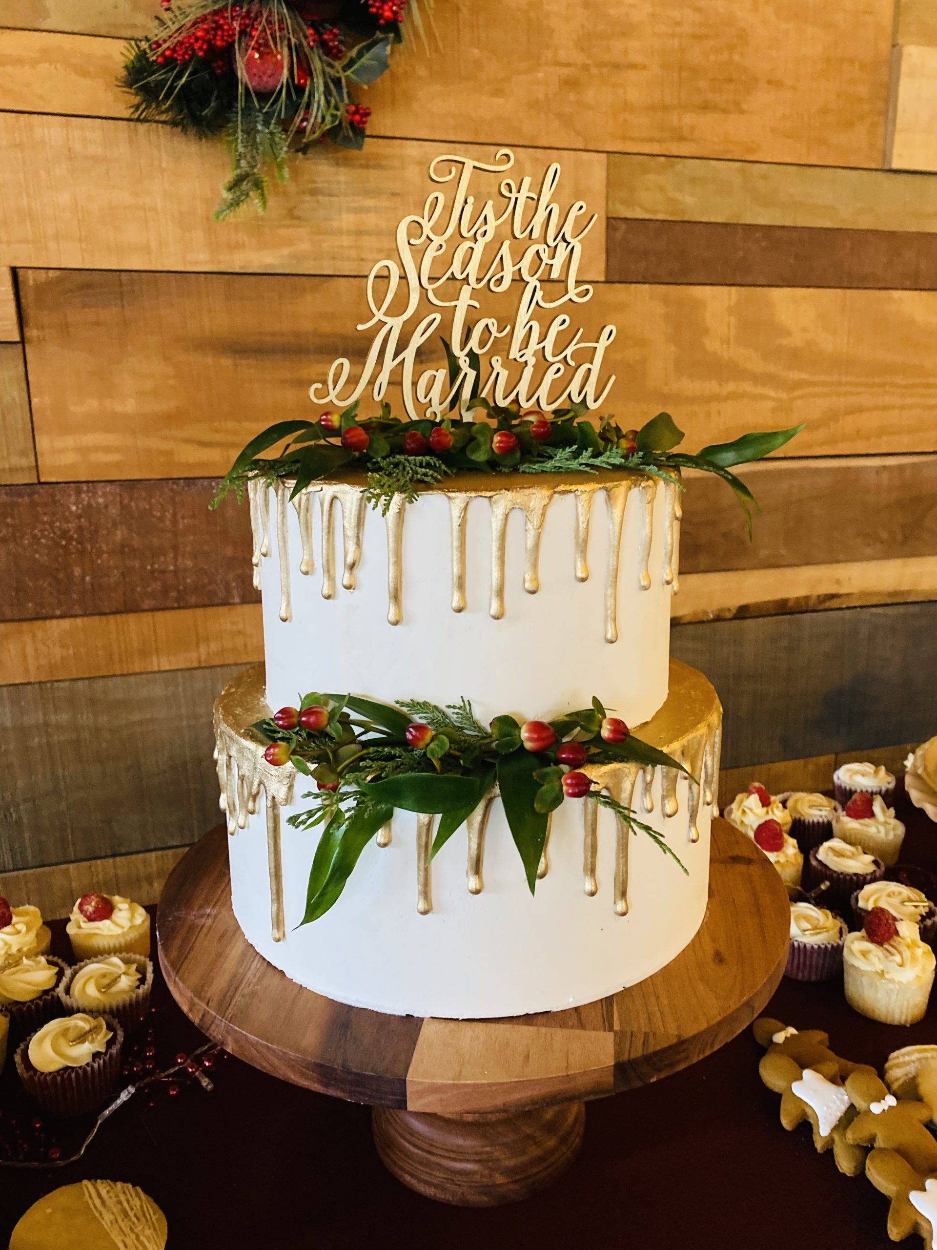 A beautiful 2-tier custom wedding cake with gold drip and fresh greenery from Village Patisserie in Toledo, Ohio