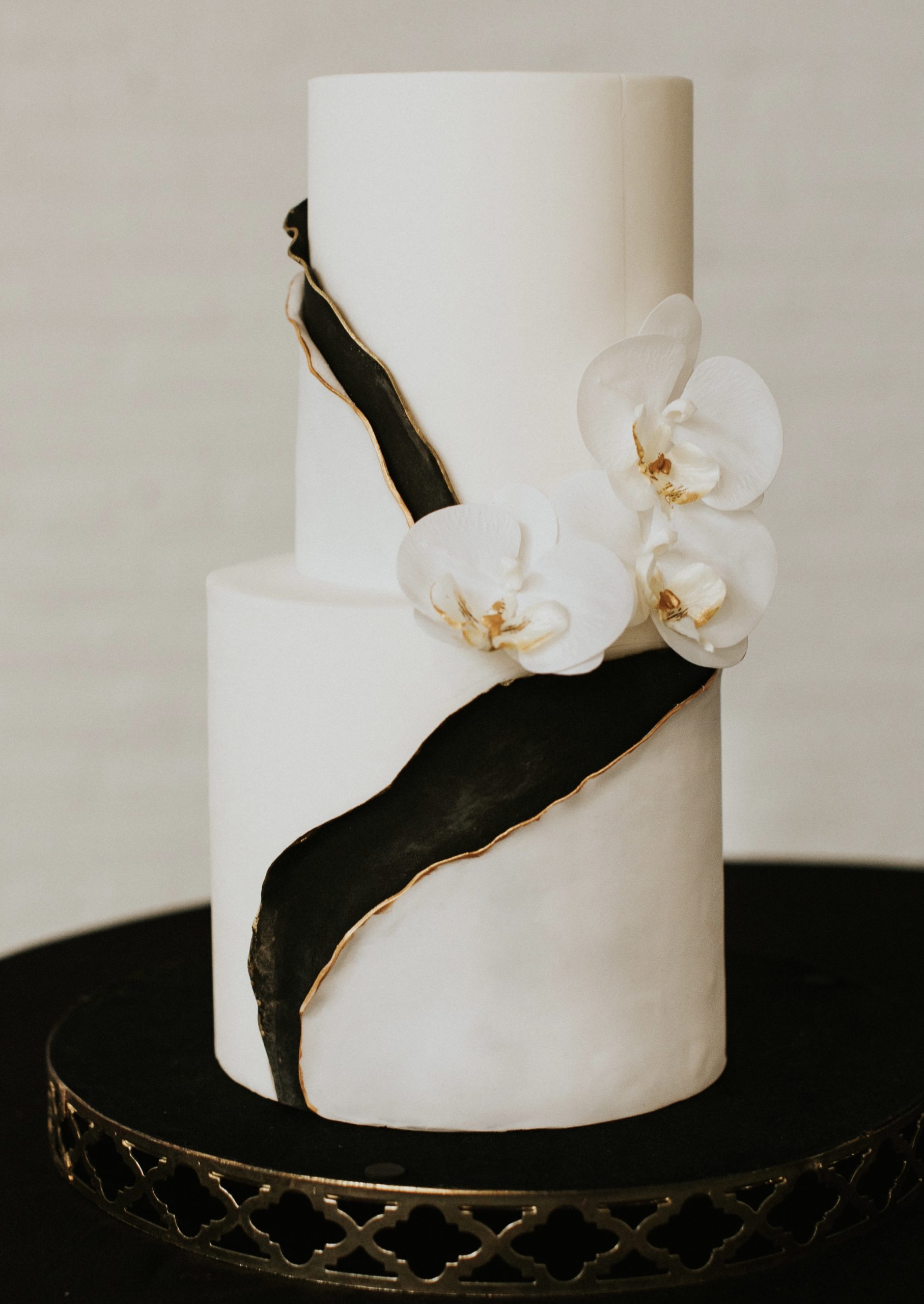 A beautiful 2-tier custom wedding cake with fondant details and live flowers from Village Patisserie in Toledo, Ohio