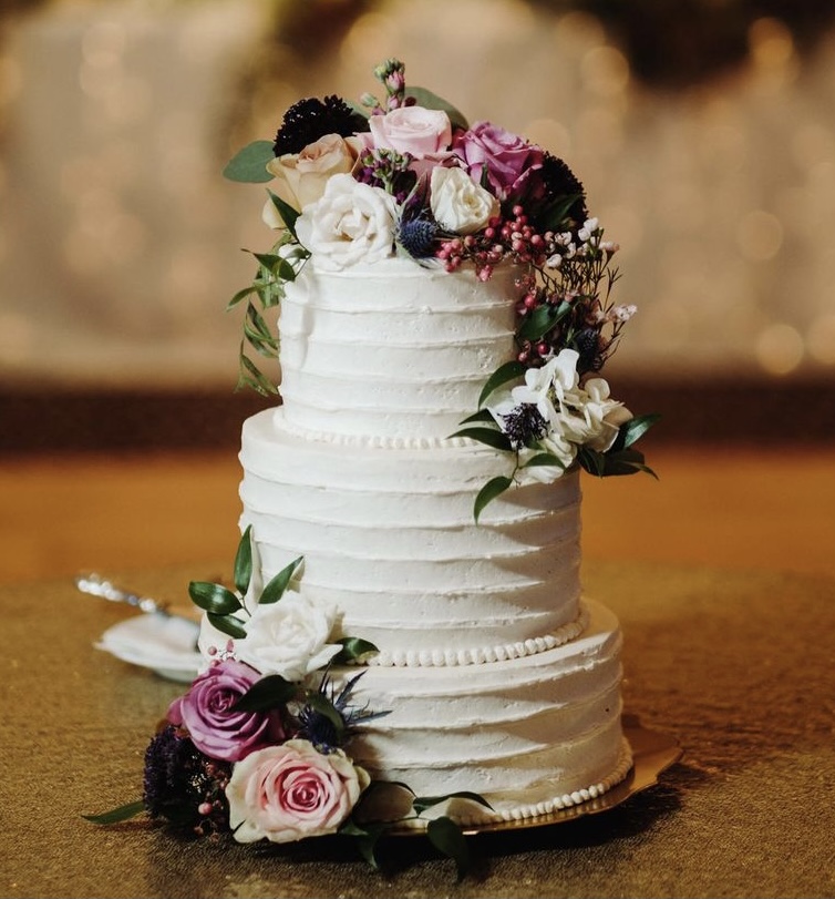 A beautiful 3-tier custom wedding cake with horizontal texture and live flowers from Village Patisserie in Toledo, Ohio