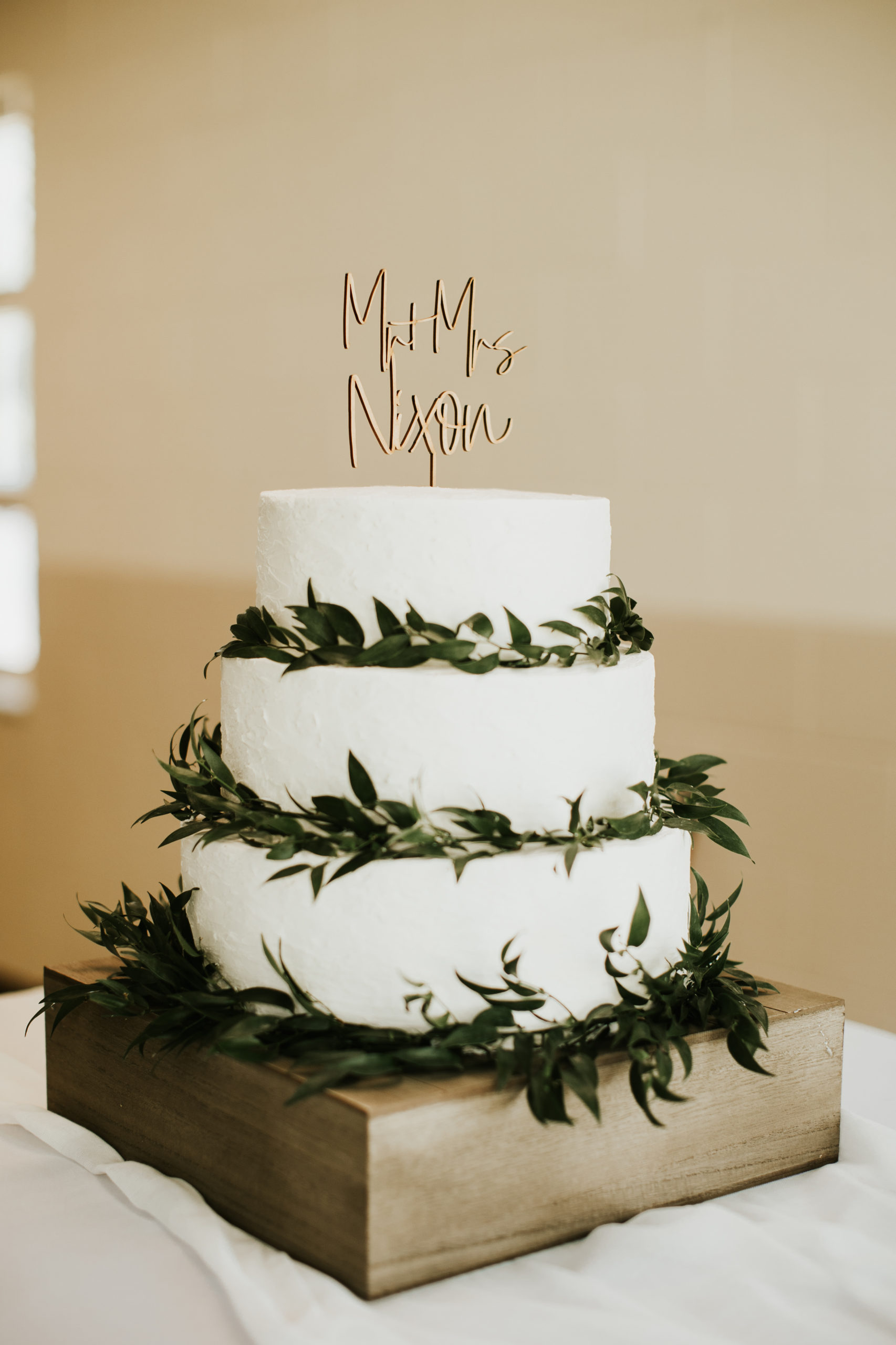 A beautiful 3-tier custom wedding cake with a rustic texture and fresh greenery from Village Patisserie in Toledo, Ohio