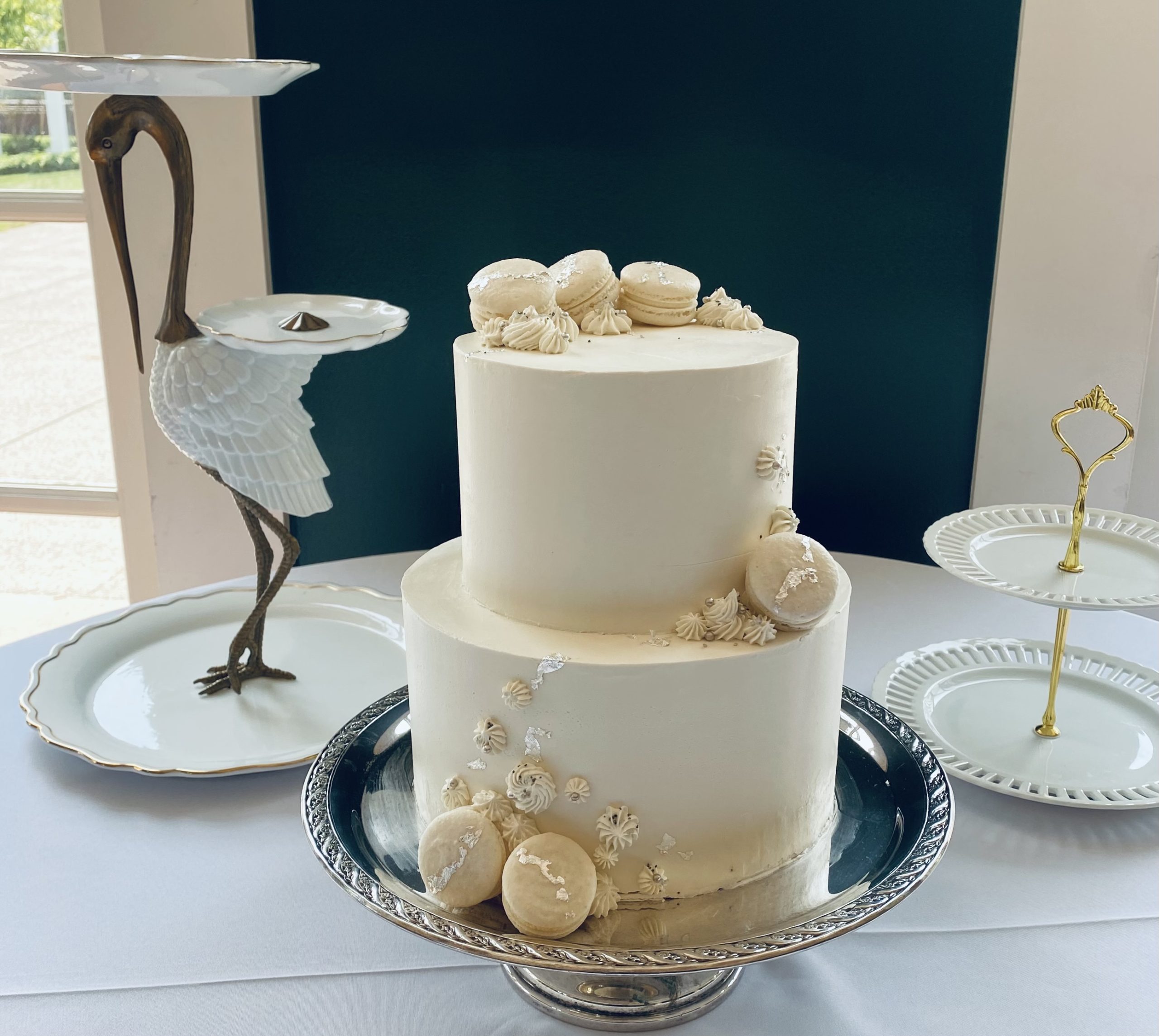 A beautiful 2-tier custom wedding cake with macarons and buttercream dollops from Village Patisserie in Toledo, Ohio