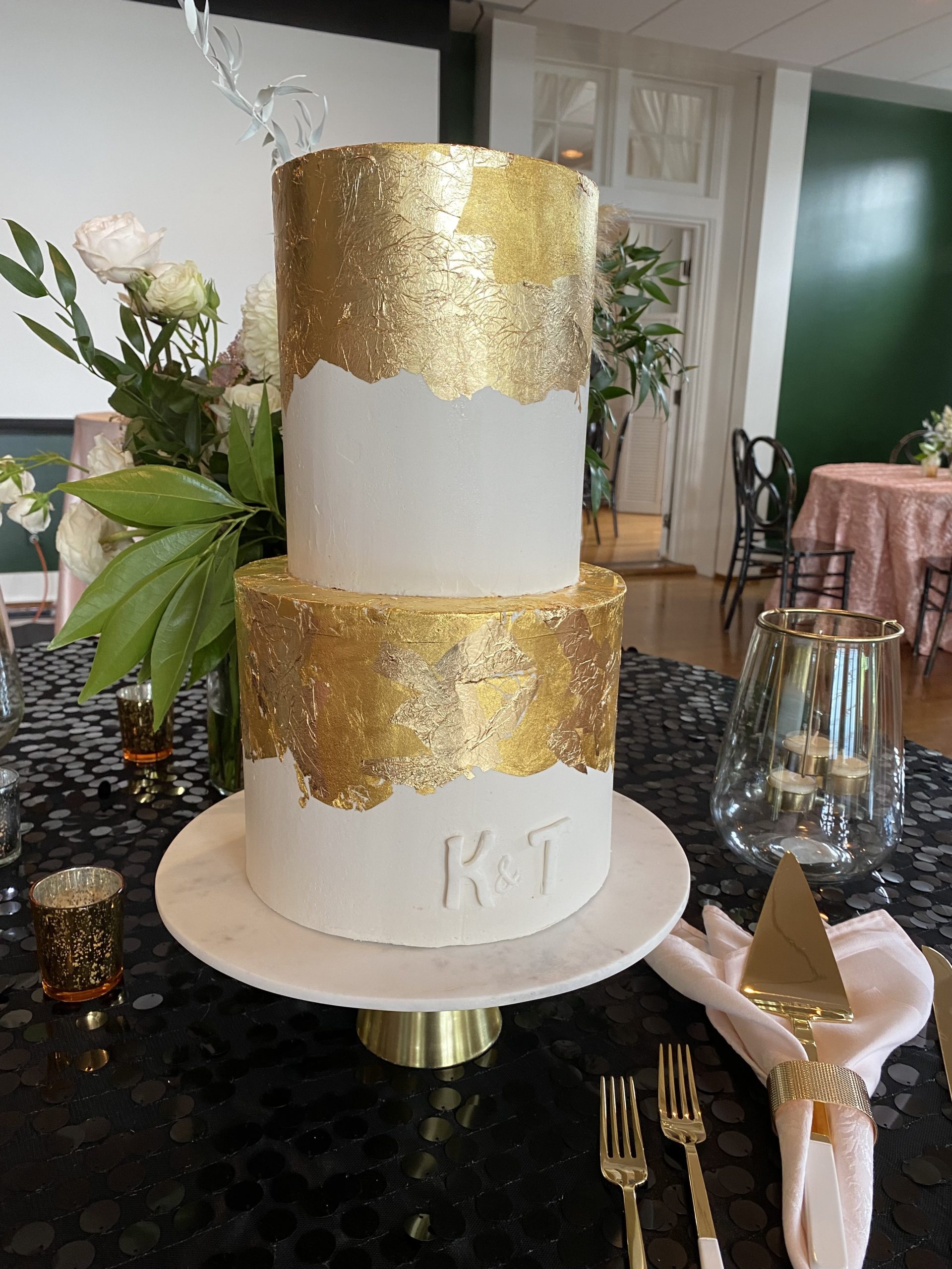 A beautiful 2-tier custom wedding cake with extensive gold leaf from Village Patisserie in Toledo, Ohio