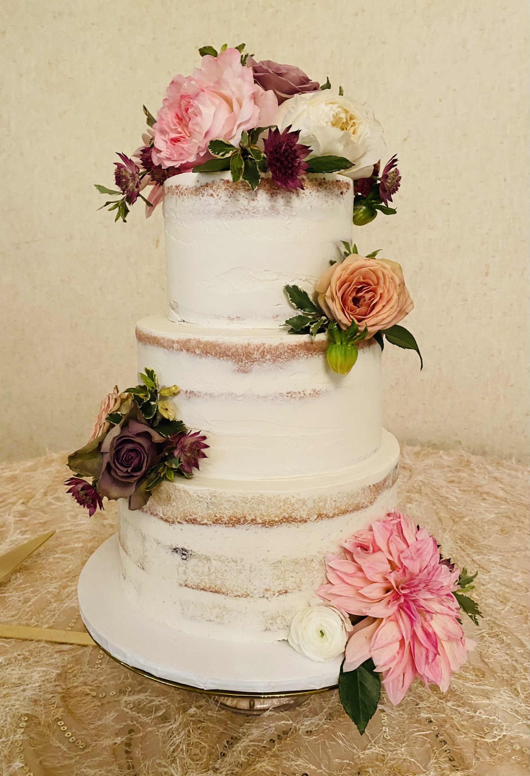 A beautiful 3-tier naked cake wedding cake with live flowers from Village Patisserie in Toledo, Ohio