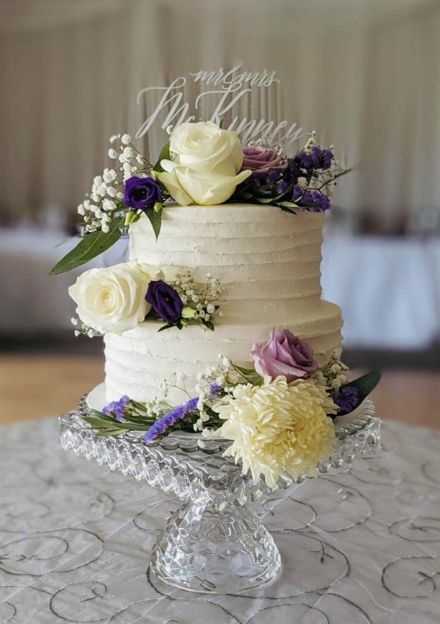 A beautiful 2-tier custom wedding cake with horizontal texture and live flowers from Village Patisserie in Toledo, Ohio